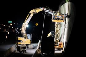 Structures Division: A Structures Division crew works on anchoring a wall along a busy highway. 