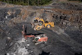 Marshalls Creek Quarry: A drill prepares a new blast area as a Caterpillar 988K loads the 769D with rock from a previous shot.