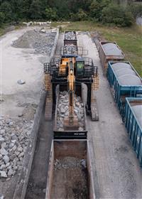 Dagsboro Stone Depot: A Caterpillar 336F Straddle Carrier unloads gondola railcars at Dagsboro Stone Depot.