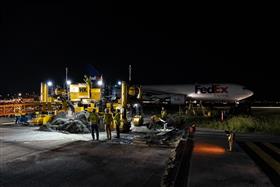 Haines & Kibblehouse, Inc.: A FedEx cargo jet passes in the background of the Gomaco paving spread at Philadelphia International Airport.